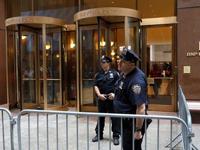 New York police officers patrol near the closed entrance to 787 7th Avenue in midtown Manhattan one day after a helicopter crashed on the building's roof in New York June 11, 2019. (REUTERS/Mike Segar)