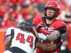 Calgary Stampeder QB Bo Levi Mitchell is pressured by Ottawa Redblacks J.R. Tavai.