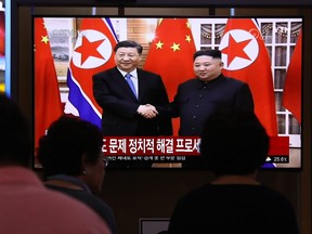 South Koreans watch on a screen showing North Korean leader Kim Jong Un shaking hands with Chinese President Xi Jinping at the Seoul Railway Station on June 20, 2019 in Seoul, South Korea. (Chung Sung-Jun/Getty Images)