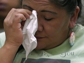 A woman wipes away tears during the Sisters In Spirit Vigil held in honour of missing and murdered Indigenous people at the Boyle Street Plaza in Edmonton on Thursday Oct. 4, 2018. (LARRY WONG/POSTMEDIA)