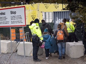 A family, claiming to be from Columbia, is arrested by RCMP officers as they cross the border into Canada from the United States as asylum seekers on April 18, 2018 near Champlain, New York. New federal data shows the Canada Border Services Agency has removed fewer than 900 asylum seekers who have crossed into Canada by exploiting a loophole in Canada's asylum laws.