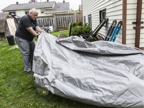 Orléans resident Wolf Schmueck cleans up his property from damage done by a tornado that touched down on Sunday evening.