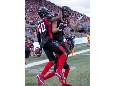 Caleb Holley (L) and Seth Coate celebrate in the end zone after extra points in the first half as the Ottawa Redblacks take on the Saskatchewan Roughriders in CFL action at TD Place in Ottawa. Photo by Wayne Cuddington / Postmedia