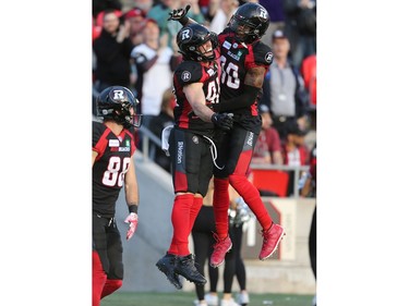 Jean-Christophe Beaulieu (L) and Caleb Holley celebrate a touchdown in the first half as the Ottawa Redblacks take on the Saskatchewan Roughriders in CFL action at TD Place in Ottawa. Photo by Wayne Cuddington / Postmedia
