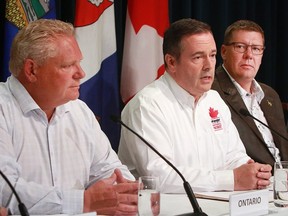 Alberta Premier Jason Kenney speaks to media on July 8, 2019 while Ontario Premier Doug Ford and Saskatchewan Premier Scott Moe listen. The Premiers were in Calgary for the annual Premier's Stampede pancake breakfast. (Dean Pilling, Postmedia News)