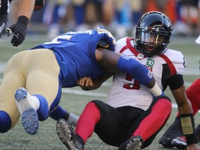 Winnipeg Blue Bombers' Willie Jefferson tackles Ottawa Red Blacks quarterback Jonathon Jennings during Friday night's game. (CHRIS PROKAYLO/Postmedia Network)