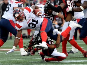 Alouettes running back William Stanback is tackled by Redblacks defensive back Sherrod Baltimore during the first half of Saturdays game.