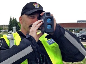 An Ottawa police officer looking through a radar gun.