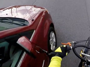 An Ottawa cyclist posted a video to YouTube on Friday, in which a minivan appears to narrowly hit the bike's handlebar mirror after an altercation on Cyrville Rd. Source: YouTube 9canadianboy For 0710 cyclist