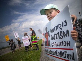 Four-year-old Owen Gibbs holds a sign during the autism rally Saturday, July 6, 2019, outside Lisa MacLeod's office on Fallowfield.