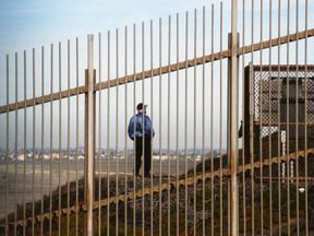 A beach visitor stands on the U.S. side of the barrier on the U.S.-Mexico border, next to the Pacific Ocean, on Jan. 8, 2019 as seen from Tijuana, Mexico.