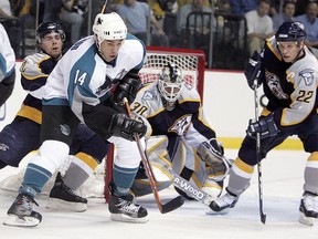 Jonathan Cheechoo of the San Jose Sharks handles the puck against Dan Hamhuis, Greg Johnson (right) and goalie Chris Mason of the Nashville Predators on April 21, 2006 at the Gaylord Entertainment Center in Nashville. (Andy Lyons/Getty Images)