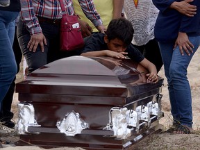 A grandson of Mexican journalist Carlos Dominguez Rodriguez mourns over his coffin during the funeral on January 17, 2018. (FRANCISCO ROBLES/AFP/Getty Images)