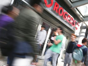 People pass a Rogers store on Yonge St. in Toronto in this 2013 file photo.