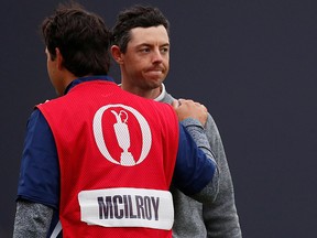 Northern Ireland's Rory McIlroy looks dejected with his caddie after not making the cut at the British Open Friday. (REUTERS/Paul Childs