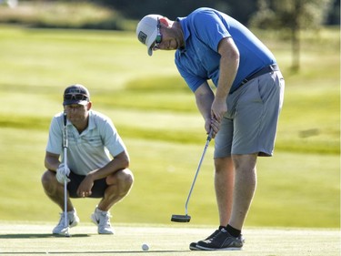 Paul Lahey, left, and partner Jeff Towner take part in the Ottawa Sun Scramble at the Marshes Golf Club on Saturday.