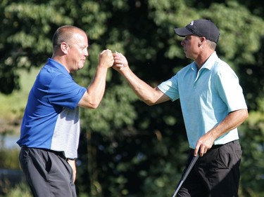 Allen McGee, right, and Kyle Koski take part in the Ottawa Sun Scramble at the Eagle Creek Golf Club on Sunday.