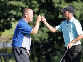 Kyle Koski (left) and Allen McGee fist-bump on their way to winning the Ottawa Sun Scramble Open yesterday at the Eagle Creek Golf Club in Dunrobin. The week-long Scramble concluded yesterday with seven division championships decided, to go with the five on Saturday.  PATRICK DOYLE/PHOTO