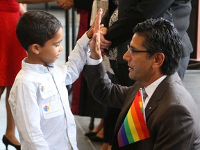 Youssef Salem, a new Canadian citizen, gets a high five from Yasir Naqvi on Thursday, Aug. 22, 2019.