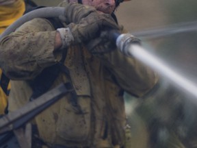 FILE PHOTO: Firefighters hose down a blaze.