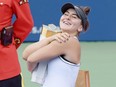 Bianca Andreescu hugs the winner's trophy after Serena Williams withdrew with a back injury during the women's final of the Rogers Cup at Aviva Centre in Toronto on Sunday, Aug. 11, 2019.