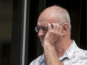 Former scout leader Donald Sullivan of Ottawa tires to cover his face as he leaves the Ottawa Courthouse on August 13, 2019.