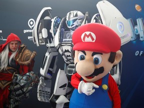 A cosplayer in the costume of Mario stands in front of Gamesbot, the official figure of Europe's leading digital games fair Gamescom, which showcases the latest trends of the computer gaming scene, in Cologne, Germany, August 20, 2019.