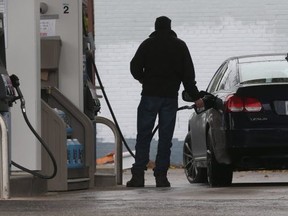 A motorist pumps gas at an Esso station in the Victoria Park-St. Clair Aves. area.