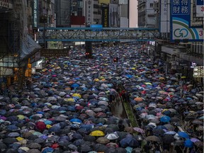 Demonstrators fill a multilane main road during a march in the Causeway Bay shopping district of Hong Kong on Sunday. After days of violence and warnings from the Chinese government, organizers estimated at least 1.7 million people had turned out to march through the dense city center in the pouring rain on Sunday, making it the second- largest march of the protests.