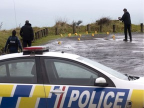 Police collect and photograph evidence in the carpark of the Te Toto Gorge lookout on Whaanga Road, south of Raglan, New Zealand, on Friday, Aug. 16, 2019.