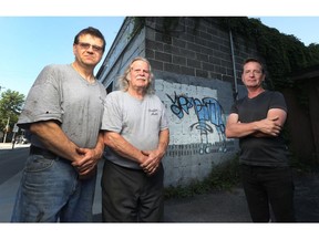 Malcolm Griffin and Louis Griffin of Griffin Automotive Services enlisted artist Christopher Griffin, right, to turn a graffiti tag into art. The a city bylaw officer stepped in.