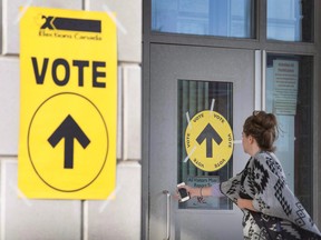 A woman enters Maple High School in Vaughan, Ont., to cast her vote in the Canadian federal election on Monday, Oct. 19, 2015. (THE CANADIAN PRESS/Peter Power)