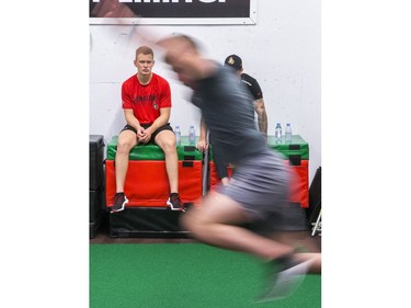 Brady Tkachuk looks on as a team mate takes a standing jump as the Ottawa Senators begin training camp with medicals and fitness testing.