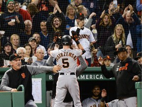 Mike Yastrzemski of the San Francisco Giants celebrates with teammates after hitting a solo home run in the fourth inning against the Boston Red Sox at Fenway Park on Tuesday night.