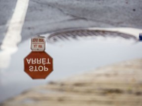 A stop sign is reflected in a puddle.