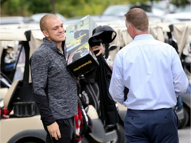 Mark Borowecki (left) takes his gift to his car before starting play. Ottawa Senators players and staff took to the Marshes Golf Club Tuesday for the Annual Bell Senators Charity Golf Classic, where foursomes are rounded out with players to raise money for the Sens Foundation.