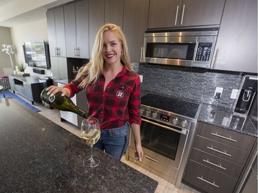 Jeff Hunt, co-owner of the Ottawa Redblacks, is selling his luxurious condo that overlooks TD Place. His partner Erin Vanasse pours a glass of wine in the kitchen.