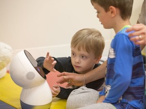 Dr. Lundy Lewis, a visiting researcher in human-AI interaction will be working with a group of children with autism to see how kids choose to interact with toys of varying levels of interactivity. James and his brother Griffin (L) are seen here with Jibo, a social interaction robot.