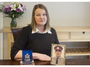 Tricia Kirkwood with her father's photo and police badge. Ottawa police constable David Kirkwood was shot and killed in the line of duty on July 11, 1977.