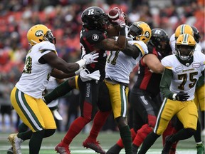 Redblacks running back Mossis Madu Jr. (23) tries to control the ball against Eskimos linebacker Larry Dean during the first half of Saturday's game.