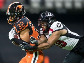 The B.C. Lions' Branden Dozier intercepts a pass intended for the Ottawa Redblacks' Nate Behar in Vancouver on Friday, Sept. 13, 2019.