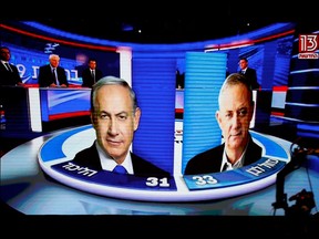 The results of the exit polls are shown on a screen at Benny Gantz's Blue and White party headquarters, following Israel's parliamentary election on Tuesday.