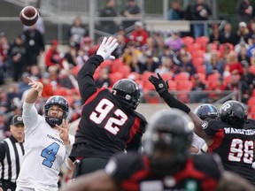 McLeod Bethel-Thompson of the Toronto Argonauts makes a throw as George Uko #92 and Michael Wakefield #96 of the Ottawa Redblacks try to block during a game on Sept. 7, 2019.