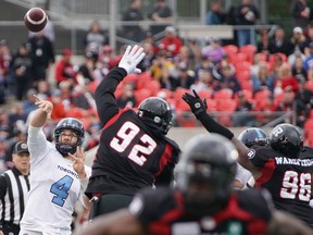 McLeod Bethel-Thompson #4 of the Toronto Argonauts makes a throw as George Uko #92 and Michael Wakefield #96 of the Ottawa Redblacks try to block. There is no pressure to focus now on the playoffs, Uko says, "Just win your week. One game at a time."