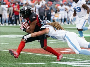 Mossis Madu Jr. #23 of the Ottawa Redblacks is tackled by Bear Woods #48 of the Toronto Argonauts during a CFL game held at TD Place, on Saturday in Ottawa.