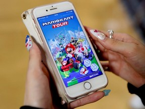 A woman shows the mobile title Mario Kart Tour on her smartphone during an interview with Reuters at Tatio's game centre in Tokyo, Japan, on Wednesday, Sept. 25, 2019.