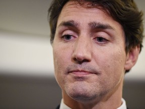 Liberal Leader Justin Trudeau reacts as he makes a statement in regards to photo coming to light of himself from 2001 wearing "brownface" during a scrum on his campaign plane in Halifax, N.S., on Wednesday, September 18, 2019.