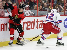 Thomas Chabot of the Ottawa Senators threads the puck through the legs of Brendan Smith of the New York Rangers on Oct. 5, 2019. Chabot is the quarterback of a power play that has gone 0-for-17 to start the season.