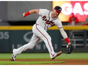 Josh Donaldson #20 of the Atlanta Braves fails to come up with this single hit by Bryce Harper #3 of the Philadelphia Phillies in the fourth inning at SunTrust Park on September 17, 2019 in Atlanta, Georgia.