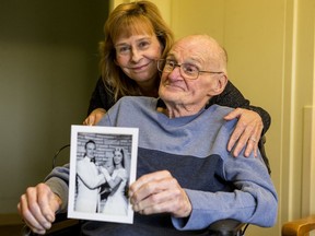 Donna Bertrand and her father Charles Diffin pose for a photo as Charles holds a wedding photo with his bride Joan. Charles and Joan are being cared for in separate health care facilities and Donna has been trying to get them united.